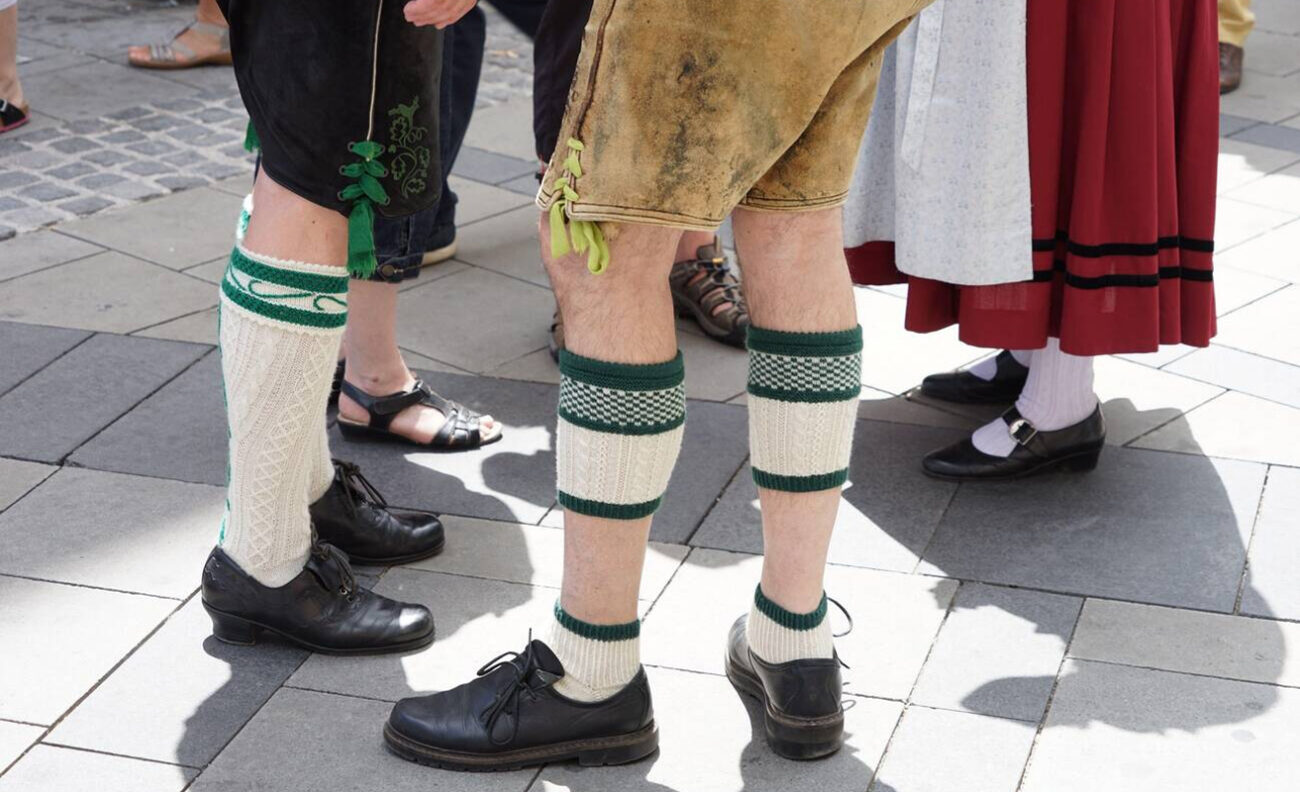A lifestyle image of a group wearing MrLederhosen’s waistcoats and jackets at an Oktoberfest table